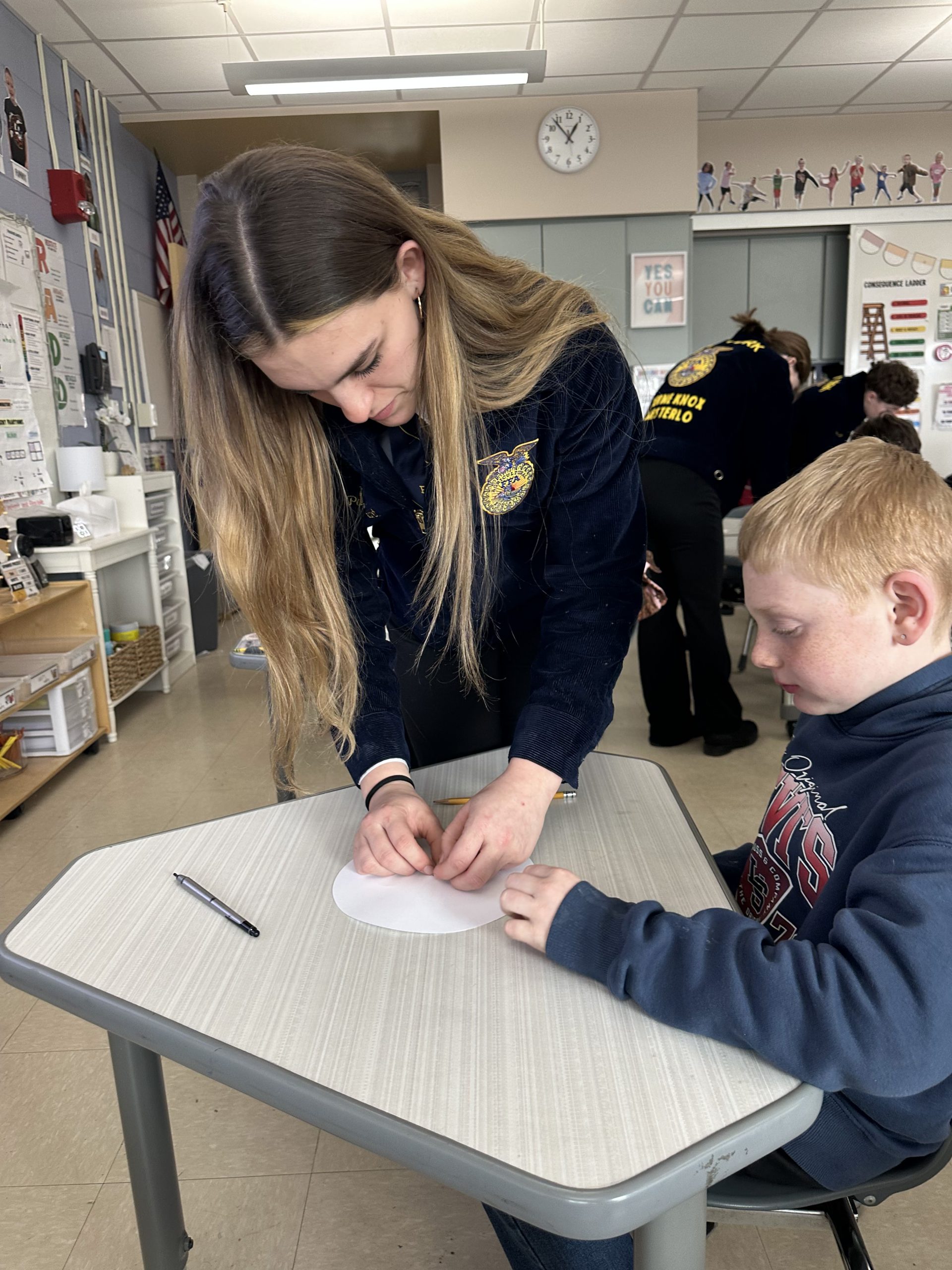FFA member lending support to a fourth grade student during Ag Literacy Week.