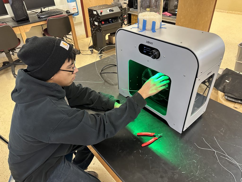 A student operating a 3D printer