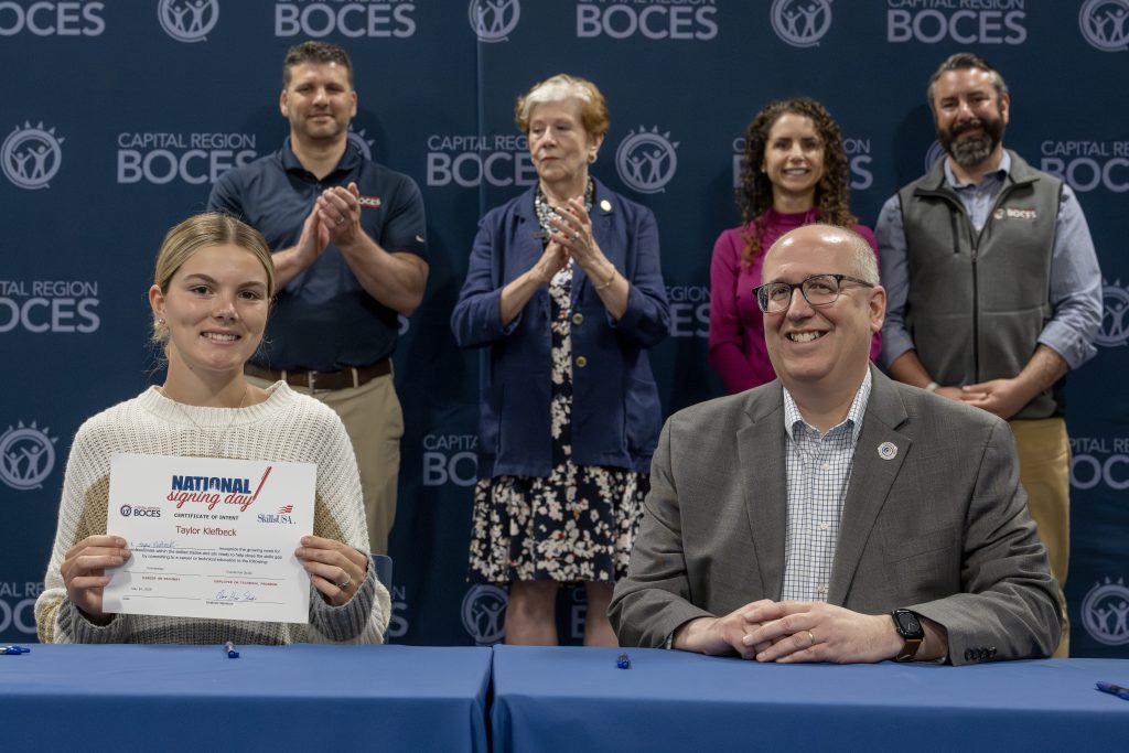 Student holding a CTE signing day certificate at the ceremony