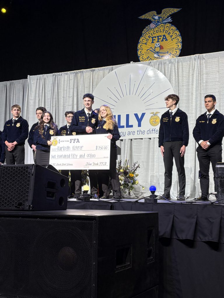 Karleigh Kehrer receiving a large check on stage