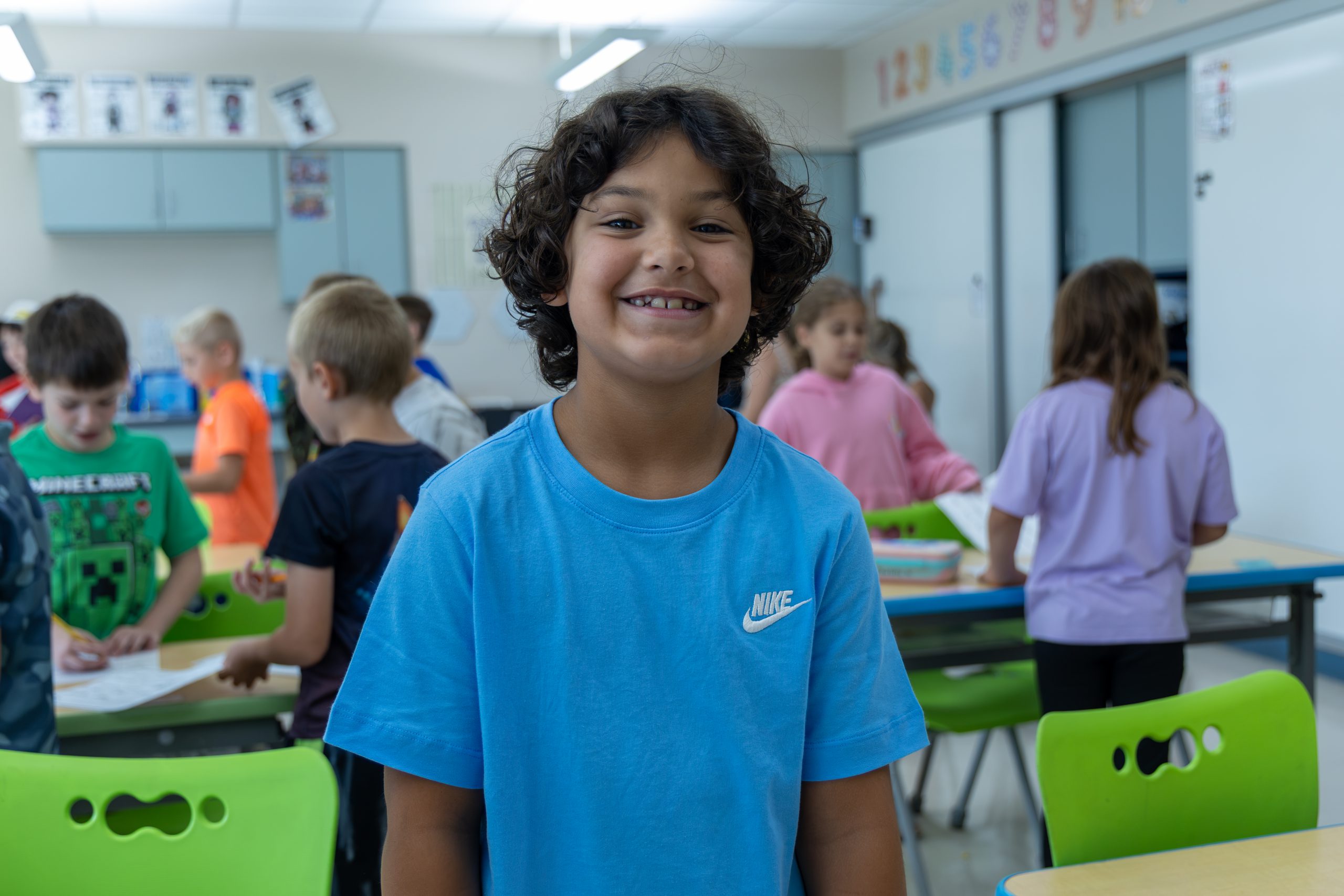 Elementary student smiling at the camera in a classroom