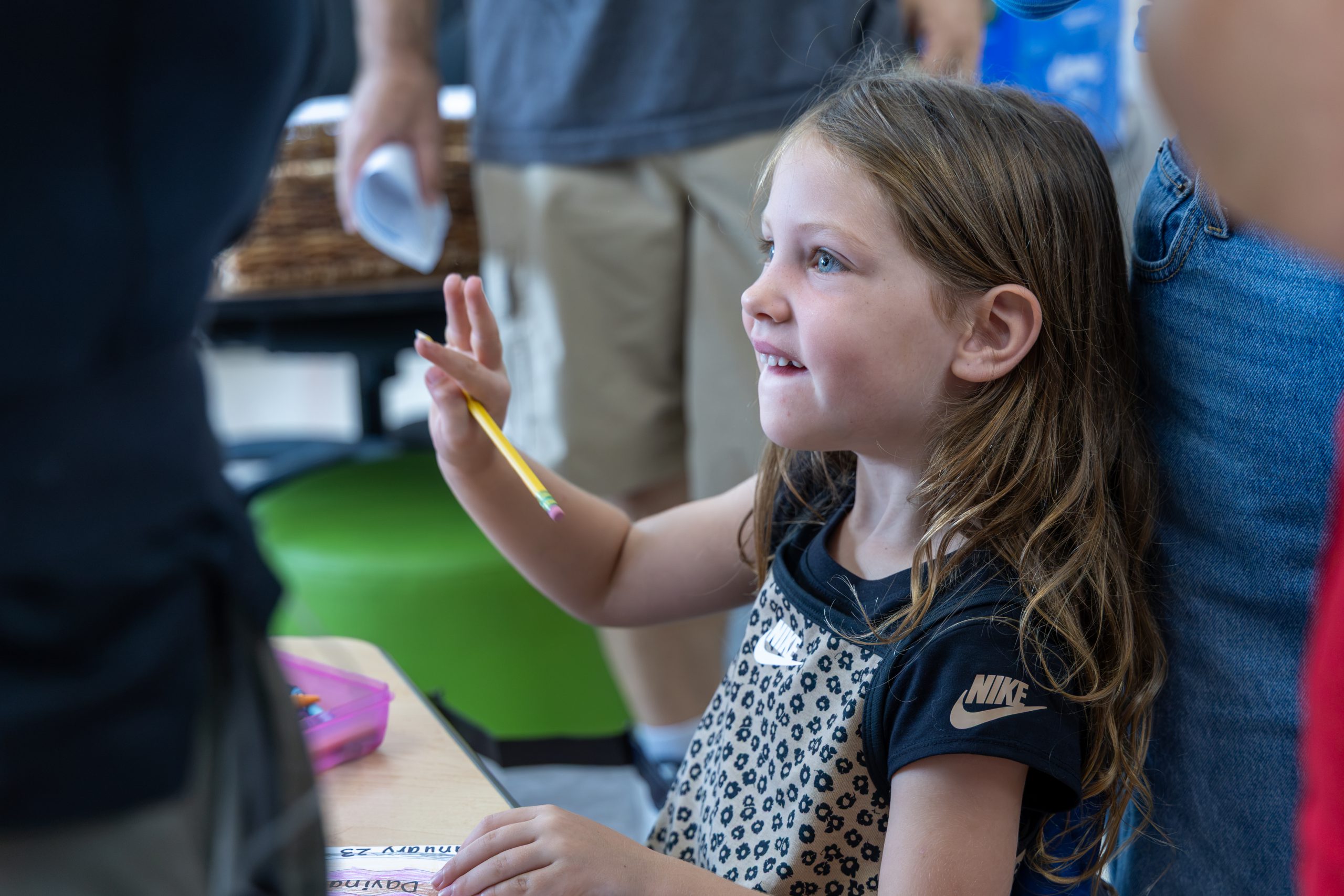 Elementary student smiling and holding a pencil