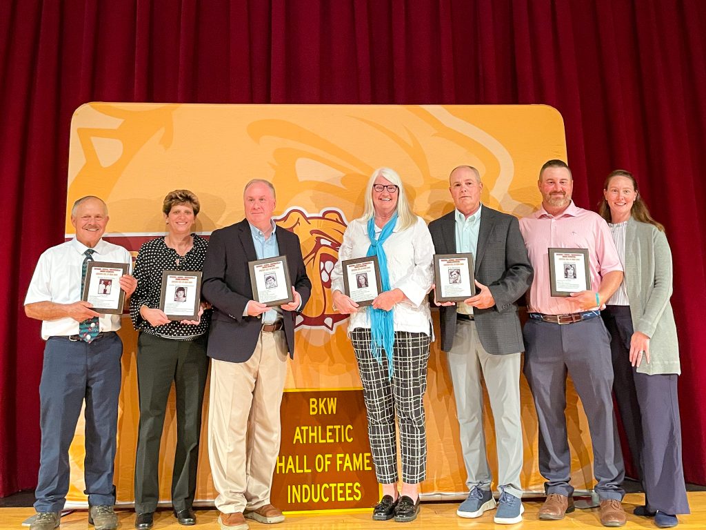 BKW Athletics Hall of Fame induction class of 2026 on stage with plaques