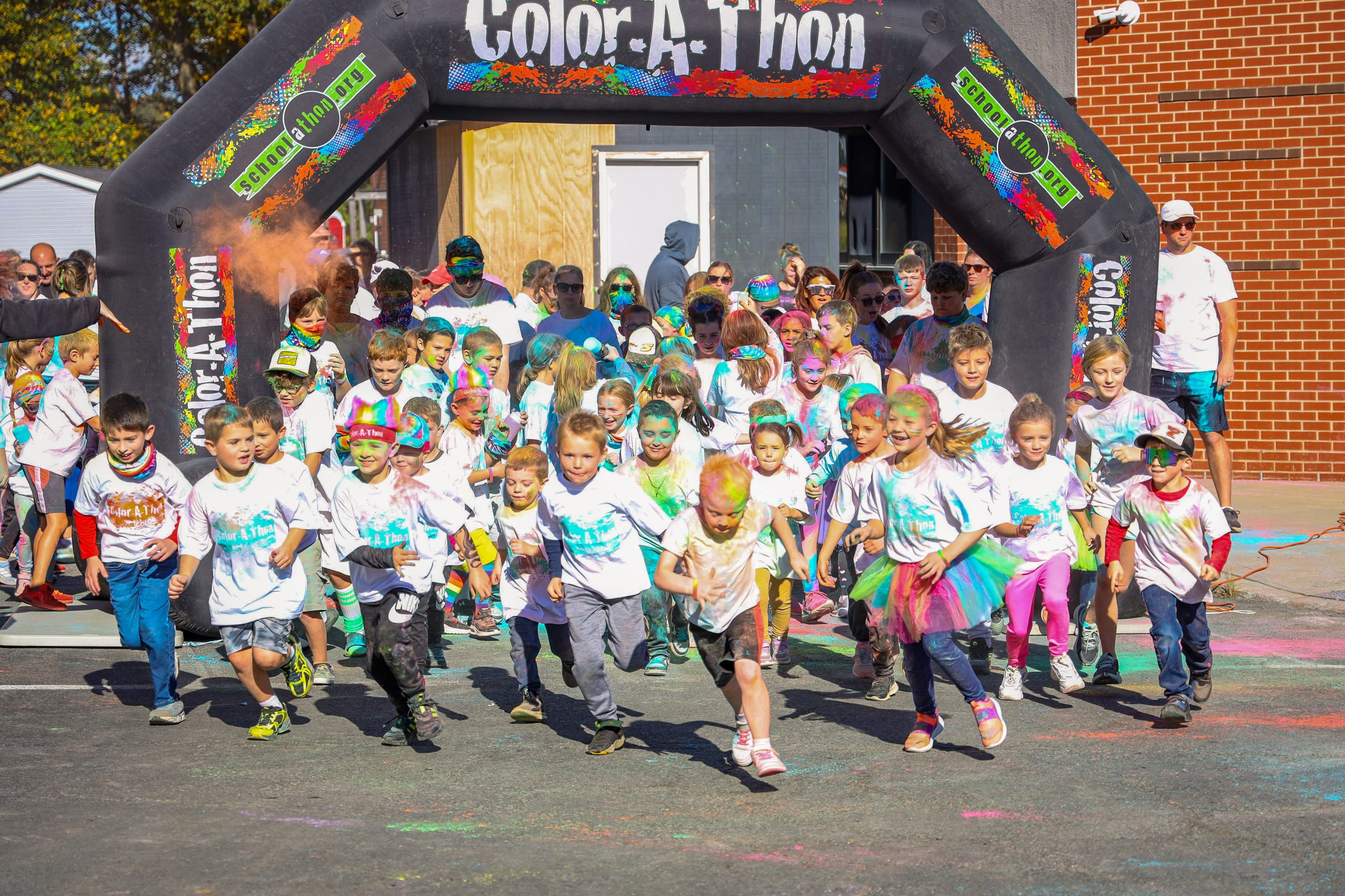 Group of students in white shirts covered in colors at the color run